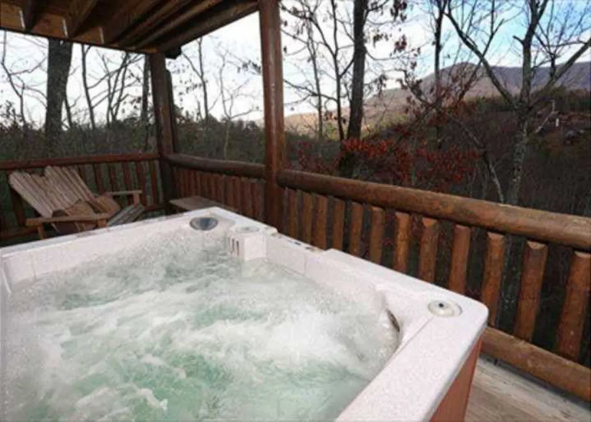 An outdoor hot tub set on a wooden deck with a view of surrounding trees, inviting families to relax and enjoy nature together after a day of adventure. The scene is tranquil, with the warm glow suggesting evening relaxation.