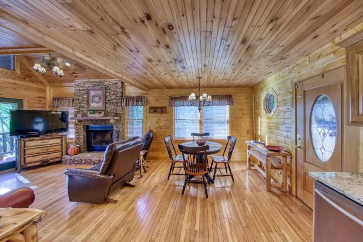 An inviting dining area with a fireplace, dining table, reclining chairs, and a television. The space is cozy and intimate, ideal for romantic candlelit dinners or family meals by the fire.